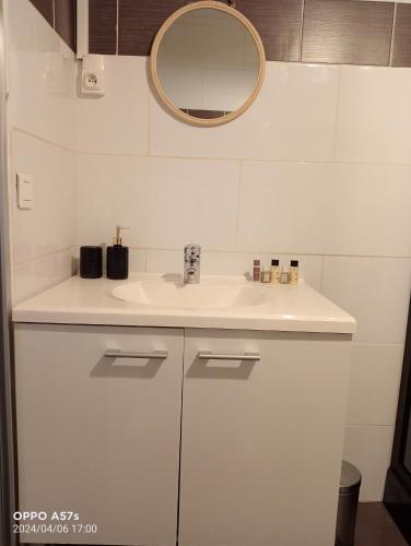 a bathroom with a white sink and a mirror at Apparemment jacuzzi balnéo centre de Bordeaux in Bordeaux