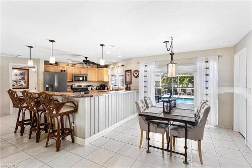 a kitchen and dining room with a table and chairs at Tropical Breeze Canal Waterfront Home, Heated Pool in Cape Coral