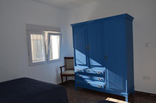 einen blauen Schrank in einem Schlafzimmer mit Fenster in der Unterkunft Casa Rural O Noso Lar in Raspay
