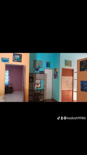 a room with blue and purple walls and a kitchen at Casa kodash in Antón