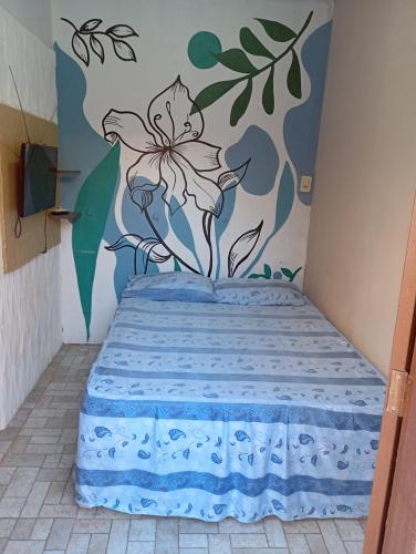 sypialnia z łóżkiem z kwiatem na ścianie w obiekcie HOSPEDARIA ITAPUÃ w mieście Santarém