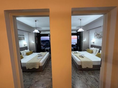 two beds in a room with two mirrors at Nikos Apartments Corfu in Agios Stefanos