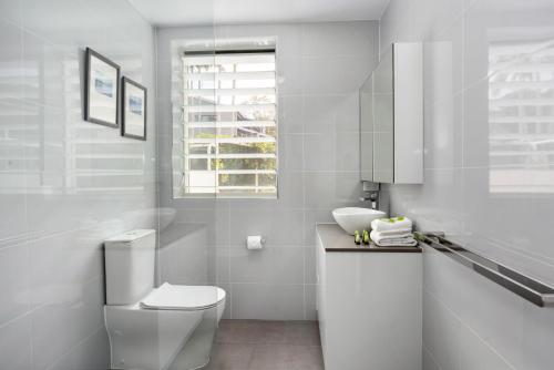 a white bathroom with a toilet and a sink at 7 28 Duke Street Sunshine Beach in Sunshine Beach