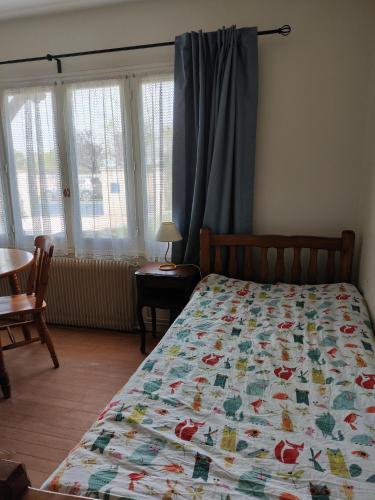 une chambre avec un lit avec une courtepointe colorée dessus dans l'établissement Chambre indépendante, à Labastidette