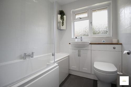 a white bathroom with a toilet and a sink at Beautiful City Centre Aprt/Sleeps 8/W Parking in Southampton