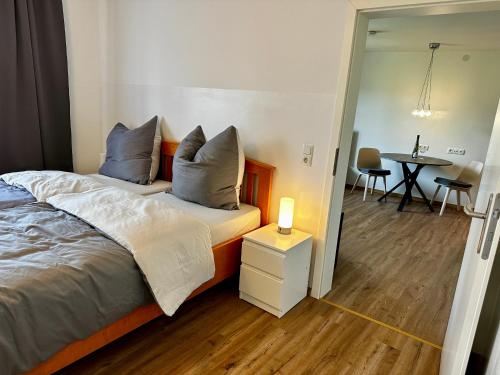 a bedroom with a bed and a table with chairs at SPEYERBACH - modernes Apartment nahe Neustadter Innenstadt in Neustadt an der Weinstraße