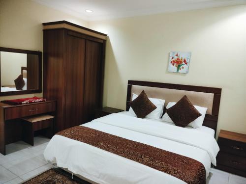 a bedroom with a large bed and a mirror at الغبيشى بلازا in Jeddah