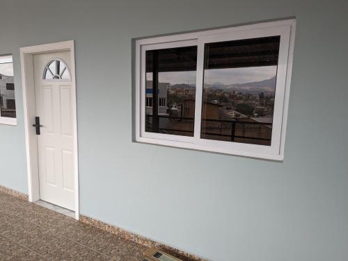 eine weiße Tür und ein Fenster mit Stadtblick in der Unterkunft Apartamento en Miraflores in Tegucigalpa