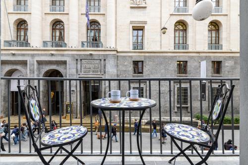 two chairs and a table with two cups on a balcony at Dimora Joseph VIA TOLEDO in Naples