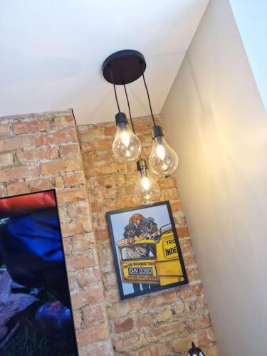a room with three lights hanging from a brick wall at The Holiday House - Portstewart in Portstewart