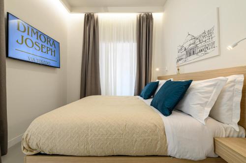 a bedroom with a bed with blue and white pillows at Dimora Joseph VIA TOLEDO in Naples