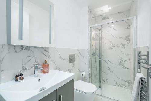 a bathroom with a shower and a sink and a toilet at Two-bedroom flat near Wembley, London in Wealdstone