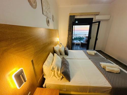 a hotel room with a large bed with a view at Nikos Apartments Corfu in Agios Stefanos