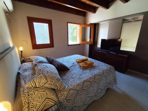 a bedroom with a bed and a television in it at Chacras de Coria Los Robles in Chacras de Coria