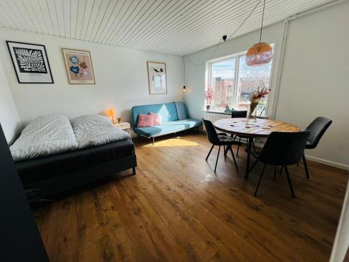 uma sala de estar com uma mesa e um sofá em The Old Hotel Silkeborg - 1TH em Silkeborg