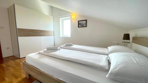 a large white bedroom with a large bed in it at Apartment More in Jadranovo