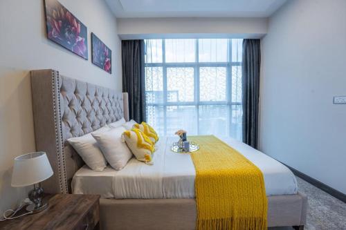 a bedroom with a bed with a yellow blanket on it at 2Bedroom Skynest Luxury Apartment Westlands City Views in Nairobi