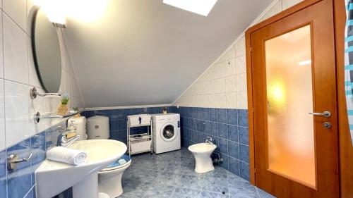 a bathroom with a toilet sink and a washing machine at Apartment More in Jadranovo