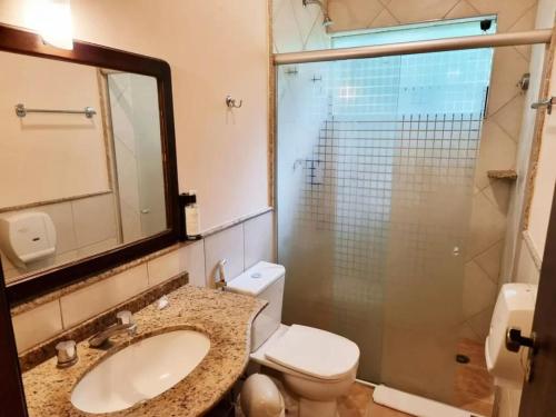 a bathroom with a toilet and a sink and a shower at Vale do Sonho Hotel in Guararema