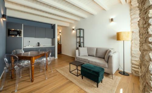 a living room with a table and a couch at Il Vicolo Suite Apartments-Il Cortiletto in Tignale