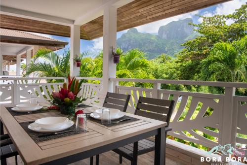 a table on a porch with a view of the mountains at Black Pearl Lodge in Bora Bora