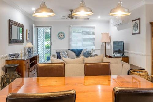 a living room with a table and a couch at BirdSong Yeronga - Inner City Village Sanctuary in Brisbane