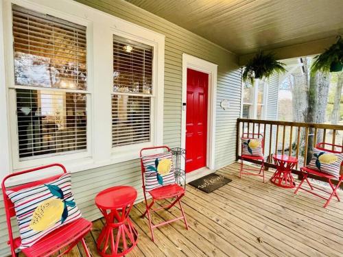 a porch with four chairs and a red door at Spacious Waterfront Cottage + 2.5 Acres on the Bay in Lafayette