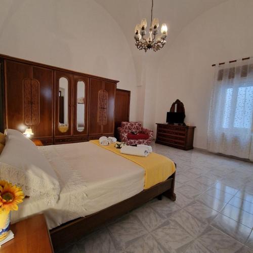 a bedroom with a large bed and a chandelier at Casa Marcel in Ugento