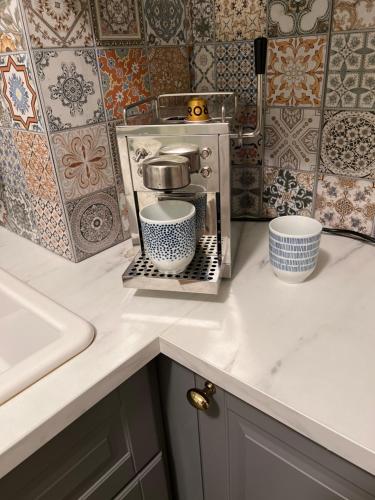 a kitchen counter with a coffee maker and two cups at Casa Dísa - Dreams, A Boutique Guesthouse in Reykjavik City`s Central Park and Botanical Garden in Laugardalur, Hot-Spring-Valley in Reykjavík