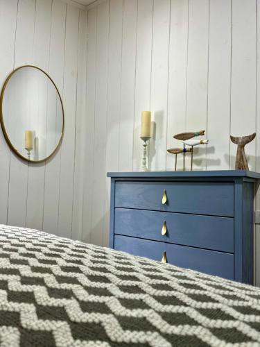 a bedroom with a blue dresser and a mirror at Curiñanco Casa Playa in Curiñanco