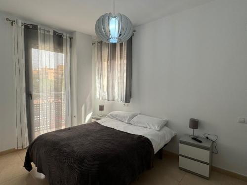 a white bedroom with a bed and a window at Experience Valencia Bnb - Mare Nostrum Apartment Beach Puerto Sagunto in Puerto de Sagunto