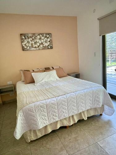 a bedroom with a bed with a white comforter at Florencia Hospedaje in Tupungato