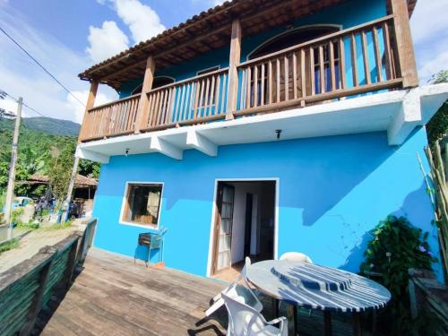 a blue house with a balcony on a deck at Refúgio na Praia in Ilhabela