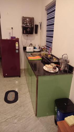 a kitchen with a counter and a refrigerator at Bekal Village Homestay in Kāsaragod