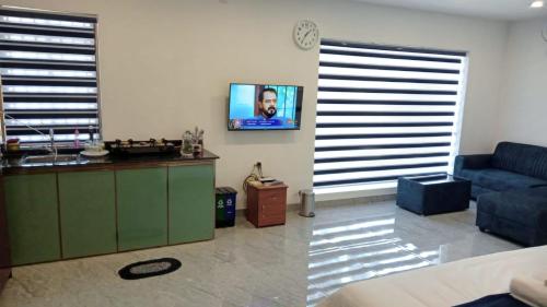 a living room with a couch and a tv on the wall at Bekal Village Homestay in Kāsaragod