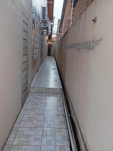 eine leere Gasse mit Ziegelwand und Fliesenboden in der Unterkunft HOSPEDARIA ITAPUÃ in Santarém