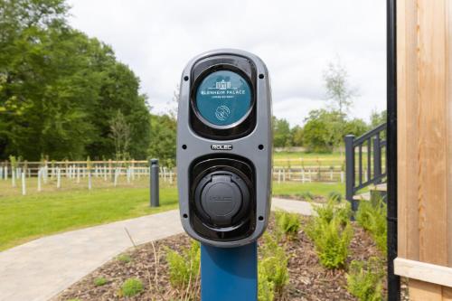 a parking meter on a blue pole in a park at Blenheim Palace Lodge Retreat in Woodstock
