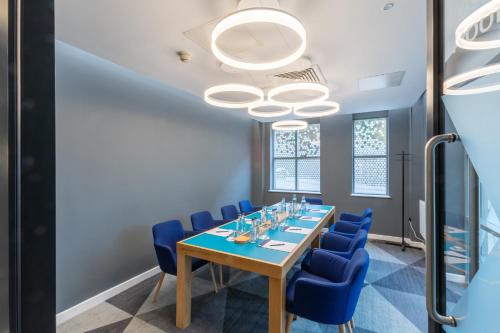 a conference room with a table and blue chairs at Holiday Inn Express London Croydon by IHG in Croydon