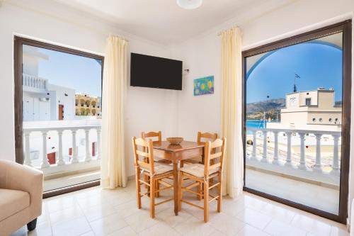 un salon avec une table et des chaises et un balcon dans l'établissement P i g a d i a B a y, à Karpathos