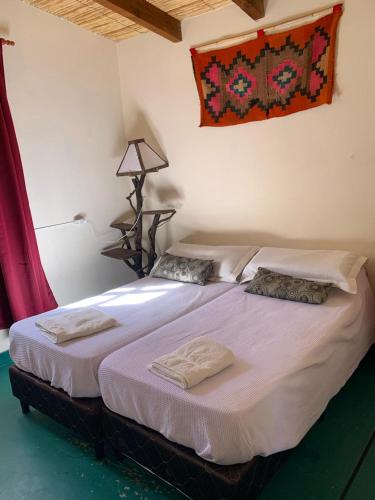 a bedroom with a bed with two pillows on it at Cabaña Cortaderas Cachi Salta in Cachí