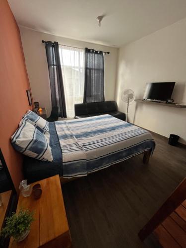 um quarto com uma cama e um sofá em Casa Tezcal em Oaxaca de Juárez