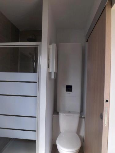 une salle de bain avec des toilettes blanches dans une chambre dans l'établissement Charmante maison avec jardin à Guidel, proche nature, à Guidel