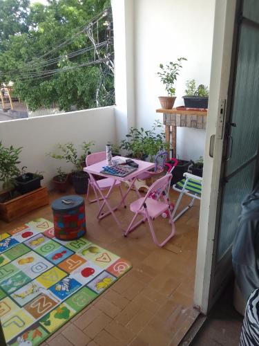eine Terrasse mit einem Tisch und Stühlen auf einer Veranda in der Unterkunft LINDO APTO CENTRAL, MOBILIADO, AO LADO DO HOTEL NACIONAL CORUMBÁ -MS in Corumbá