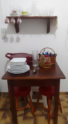 una mesa de madera con platos y una cesta. en LINDO APTO CENTRAL, MOBILIADO, AO LADO DO HOTEL NACIONAL CORUMBÁ -MS, en Corumbá