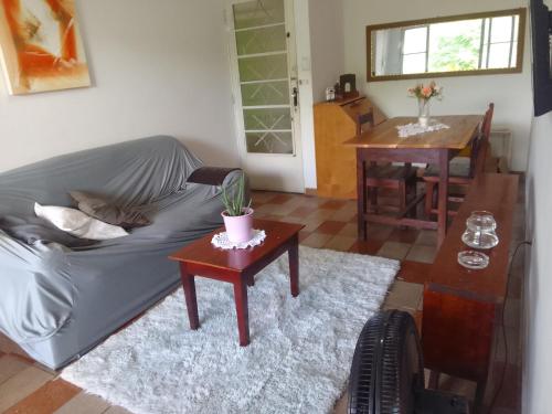 a living room with a couch and a table at LINDO APTO CENTRAL, MOBILIADO, AO LADO DO HOTEL NACIONAL CORUMBÁ -MS in Corumbá