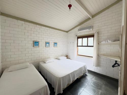 Giường trong phòng chung tại Condom North Shore Maresias - Casas de 2 quartos -2 banheiros -piscina 1 q da praia - estacion-churrasq indiv-wifi animais de peq porte