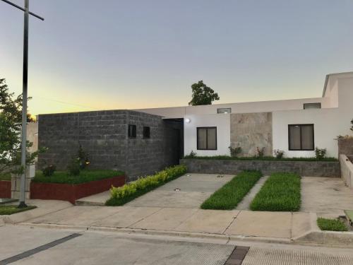 une maison avec un mur en briques et une allée dans l'établissement Alojamiento en San Juan Opico, à San Juan Opico
