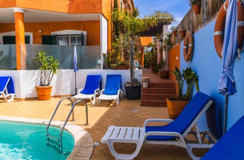 a patio with chairs and a swimming pool at Casas Novas Guesthouse - Adults Only in Lagos
