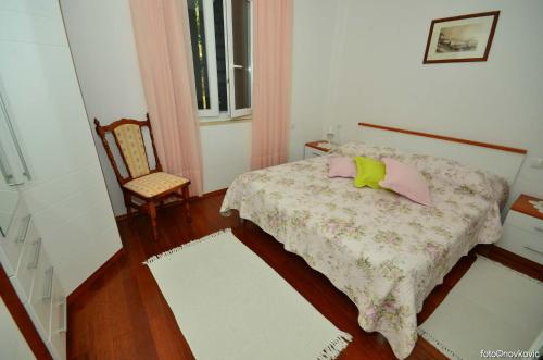 a small bedroom with a bed and a chair at Apartments FANI KANUN in Bol