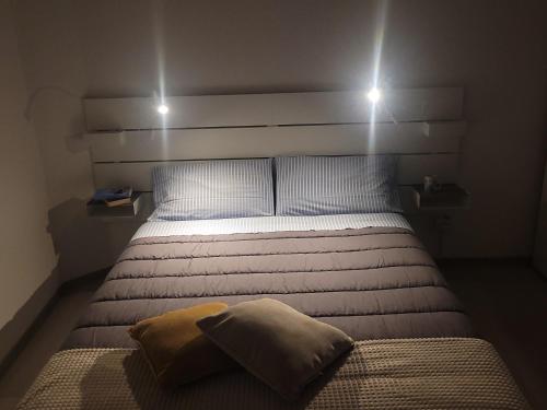 a bedroom with a bed with two lights above it at La casetta in Cuneo